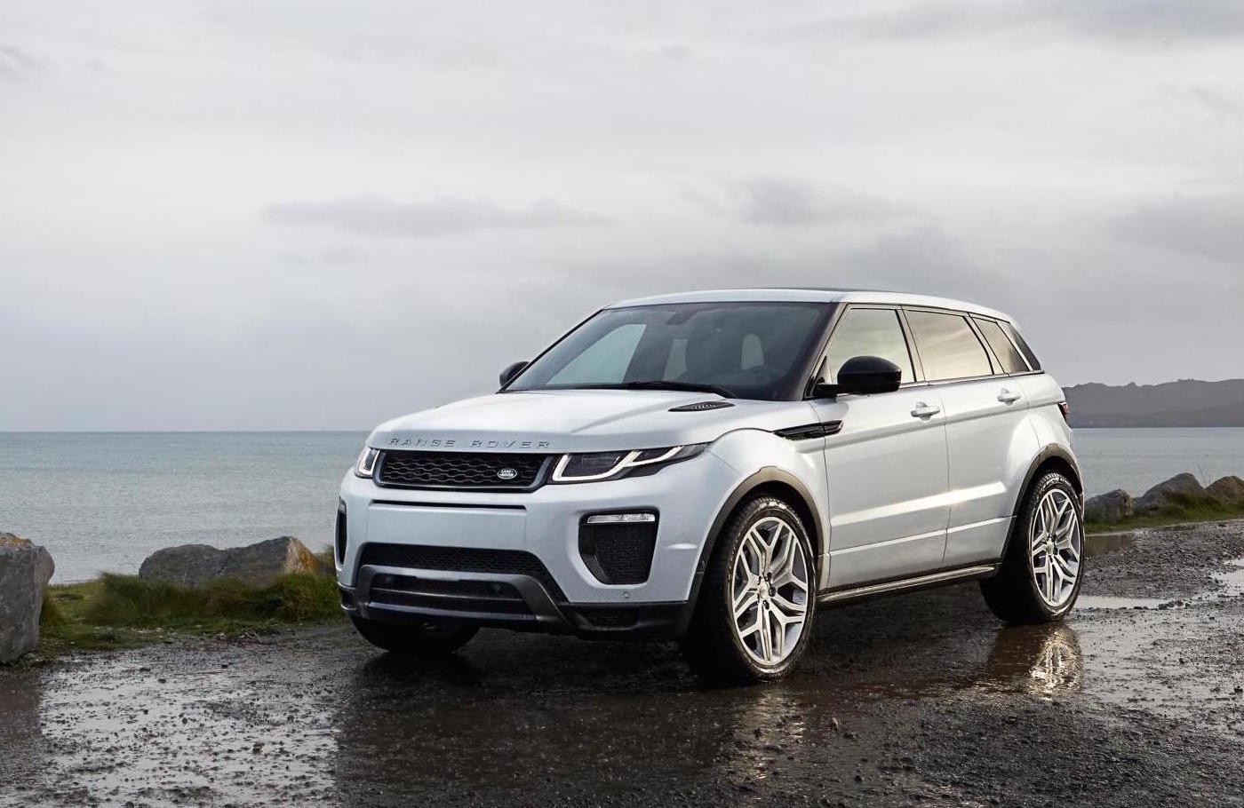 White Range Rover Evoque parked overlooking a lake view.